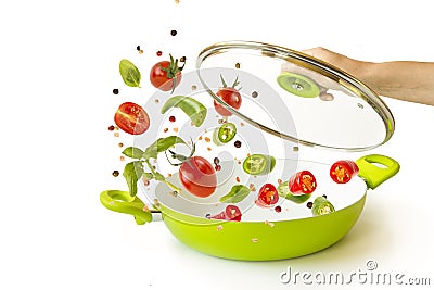 Levitation.They throw fish and vegetables with spices in a green pan. items on white background. Flying Food Stock Photo